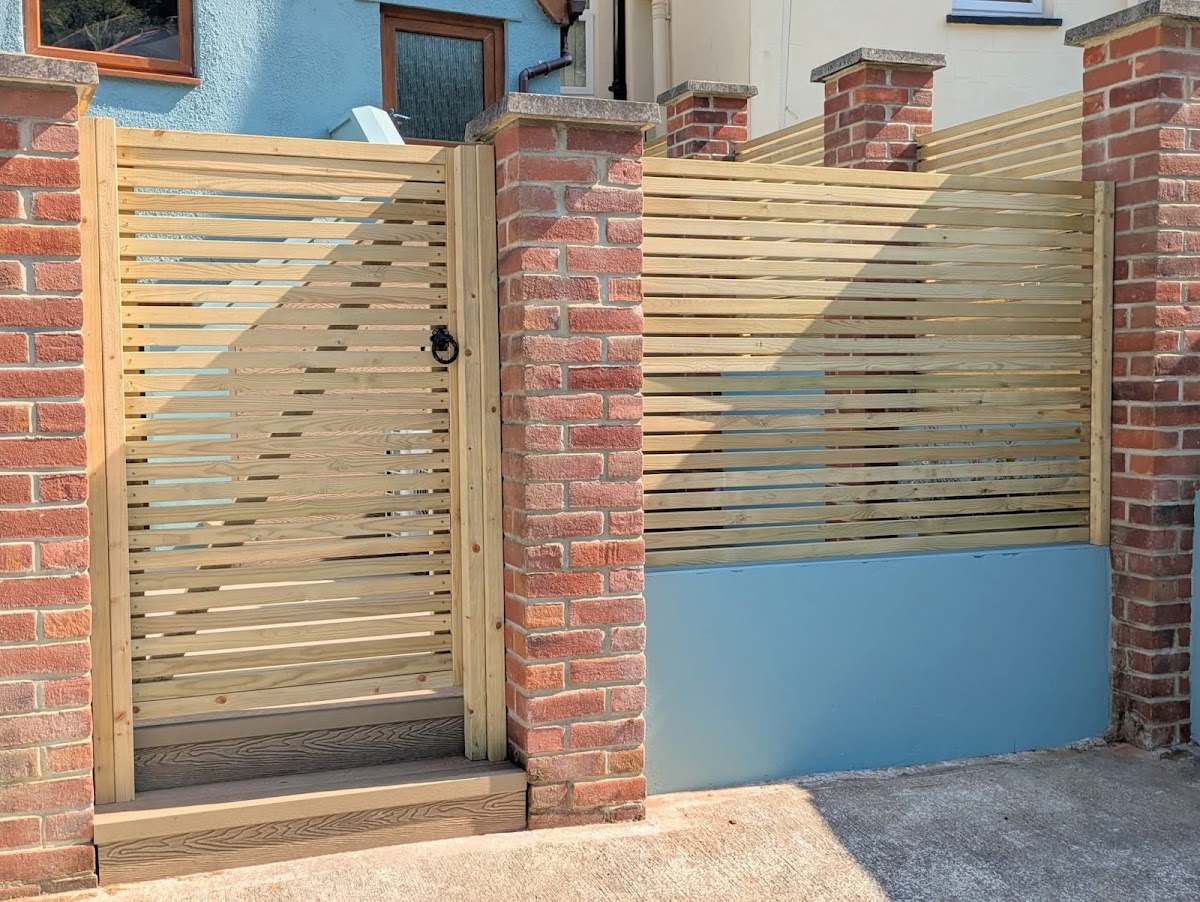 Bespoke slatted timber gate and screen fence between brick pillars in Dartmouth