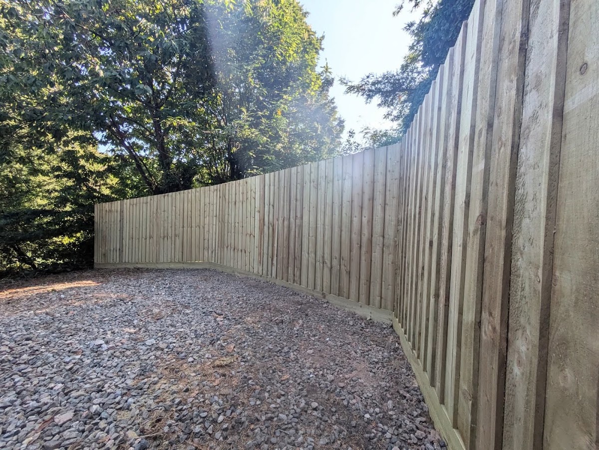 New closeboard timber fence run along a garden boundary